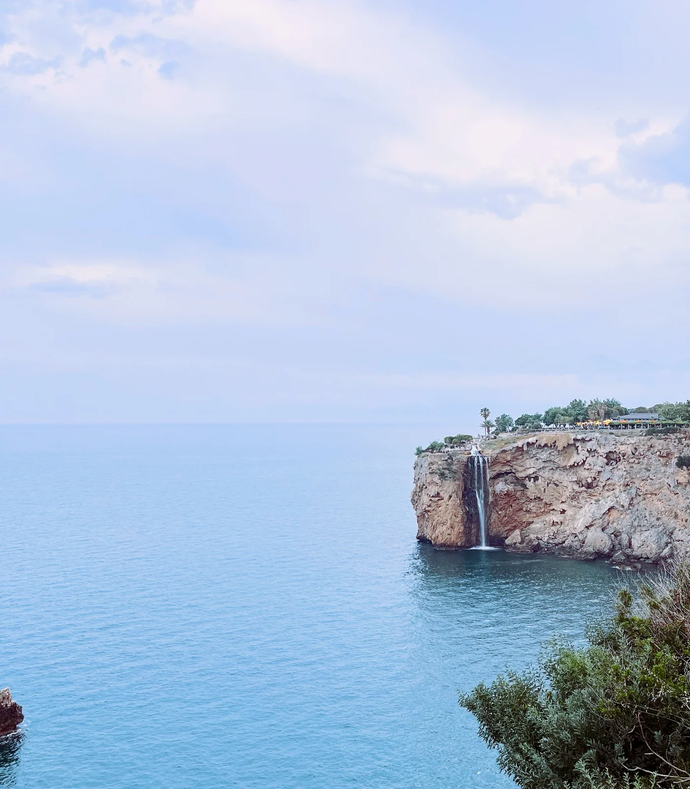 A quiet Mediterranean coastline with cliffs above the blue sea